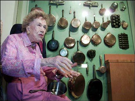 Julia Child and her pegboard wall of cookware.