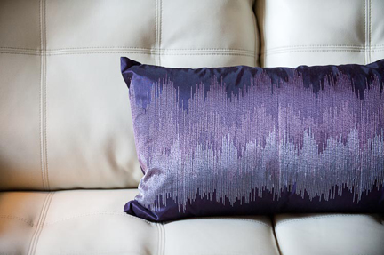 cream-leather-sofa-purple-pillow