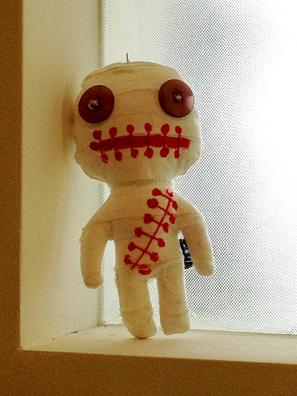 Propped in the corner of a powder room window, this voodoo doll cracked me up.