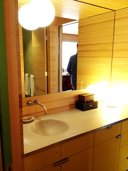 Love the combination of the circular sconce mounted on the mirror and the globe table lamp on the vanity!