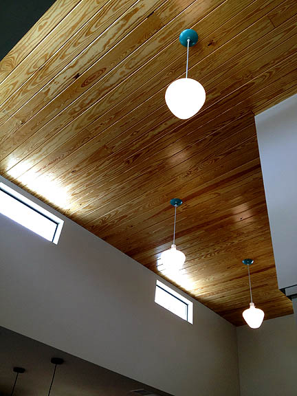 Painting the ceiling collars on these pendants adds a fun detail to this wood ceiling.