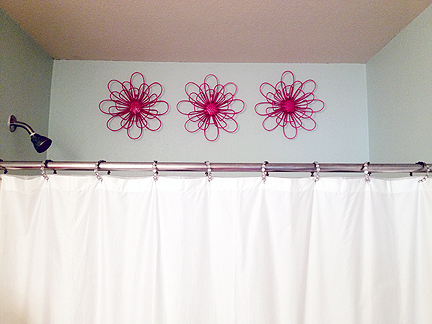 These hot pink metal flowers peeking over the top of Phoebe's bathtub are indestructible pieces of bathroom art.