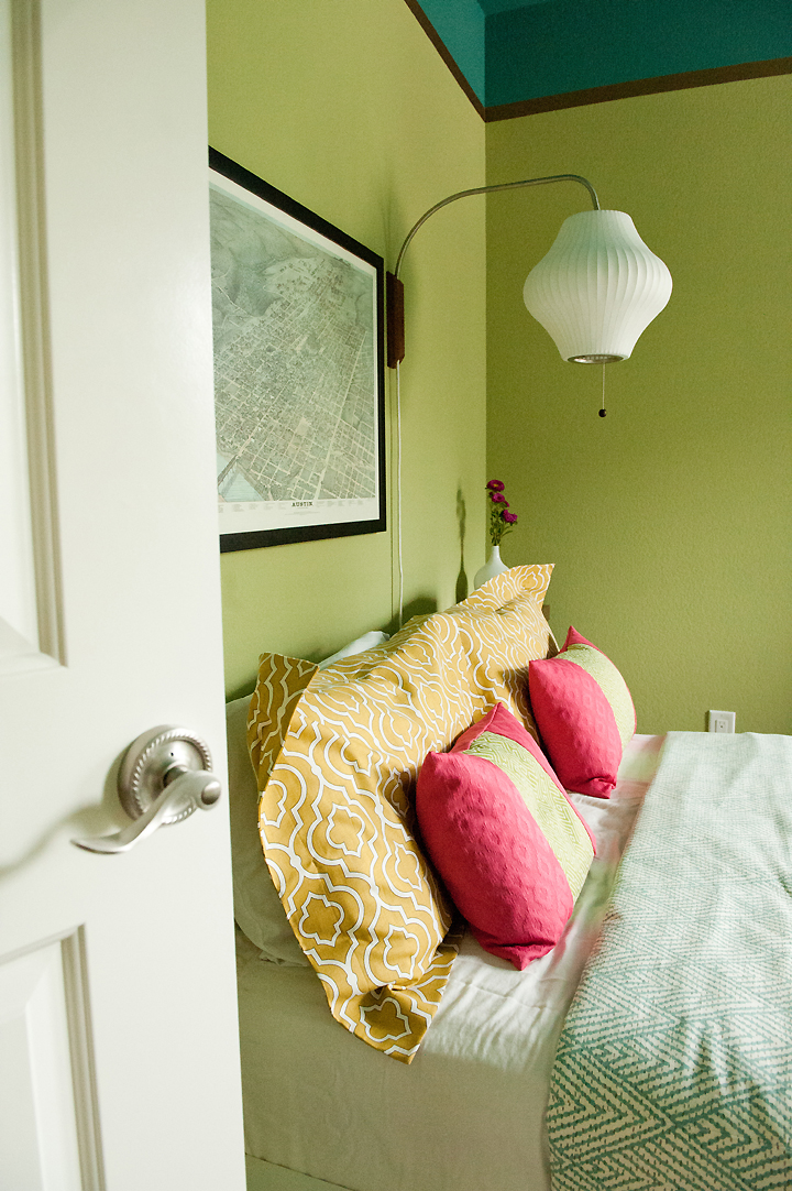 This colorful & modern guest bedroom features a mid-century Nelson wall sconce and fun, vibrant bedding. Designed by Room Fu - Knockout Interiors. Photo by Suzi Q. Varin / Q Weddings.