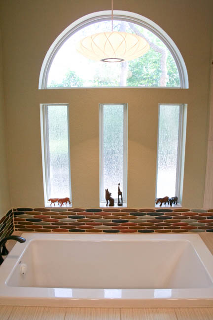 Mid century modern master bathroom remodel in Austin, TX featuring glass mosaic tile in earth tones.