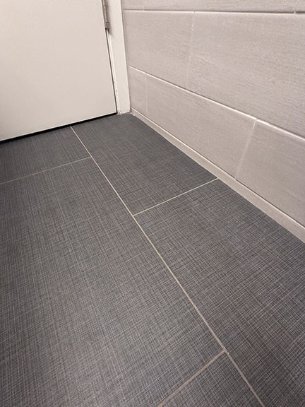 Fabric textured gray floor tile closeup photo in Austin modern bathroom remodel.