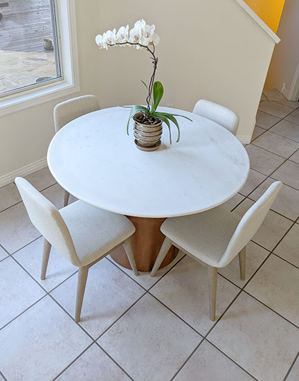 West Elm Anton Round Marble Dining Table and Zoe Dining Chairs from Pottery Barn combine to create a beachy breakfast space