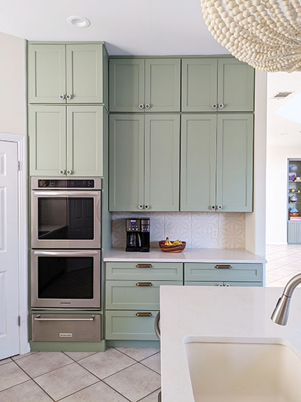 Kitchen remodel featuring stacked cabinets painted SW 6192 Coastal Plain, Aster Cream porcelain tile backsplash by Annie Selke, and creamy quartz countertops