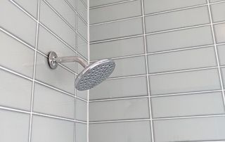 Spa bathroom featuring Arizona Tile Vetri in Acqua and chrome showerhead.