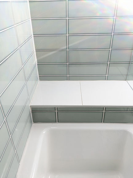 Spa bathroom featuring Arizona Tile Vetri in Acqua and white bench seat