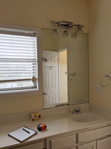 Bathroom vanity, mirror and vanity light before remodel.