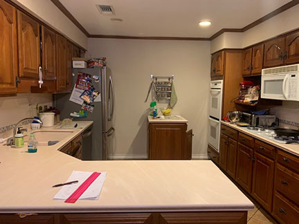 Austin kitchen before remodeling, featuring outdated country cabinets, clunky portable island, and an odd layout.