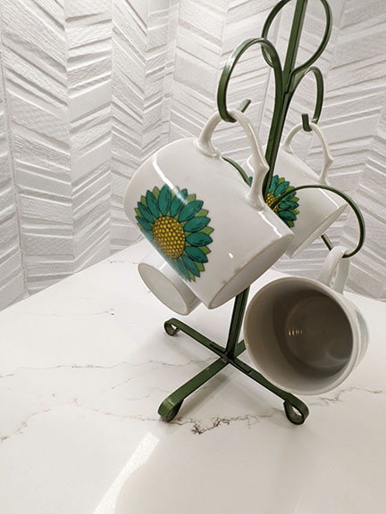 New textured chevron porcelain tile kitchen backsplash and quartz countertops, with vintage green mug stand.