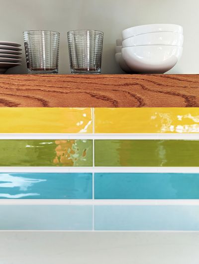 Close-up detail of colorful backsplash and floating shelves in Austin kitchen remodel designed by Room Fu.