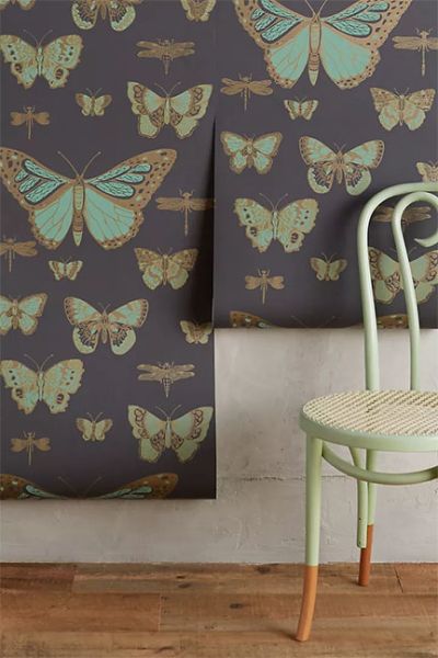 Cole & Son Lepidoptera Wallpaper, available at Antrhropologie, features moths and butterflies in a dark palette of charcoal and teal.